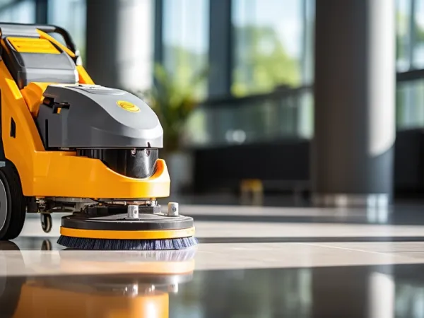 Autolaveuse professionnelle jaune sur le sol brillant d'un hall lumineux